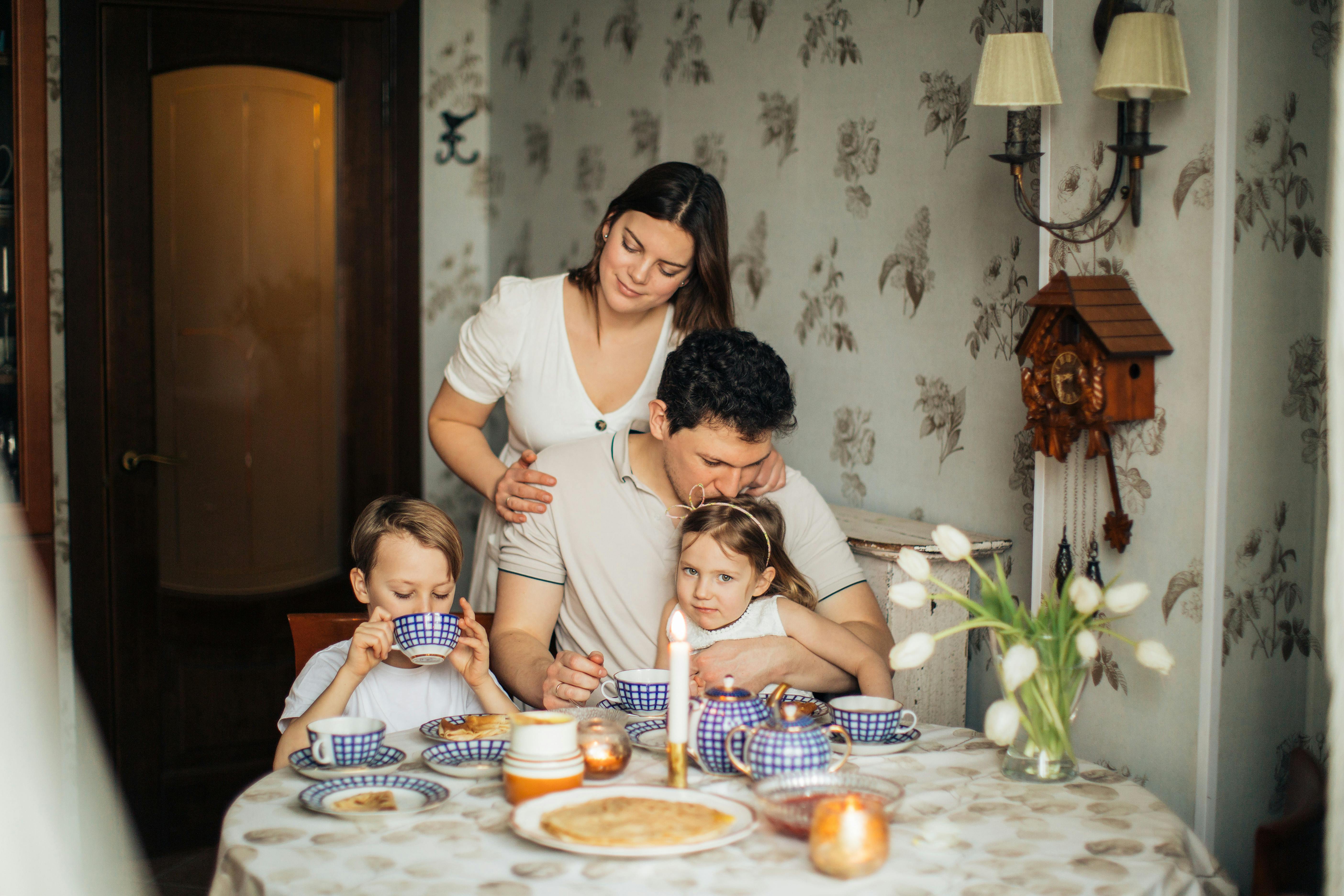 Family at breakfast table with children, showing the daily care and household management that stay-at-home parents provide and protect with life insurance