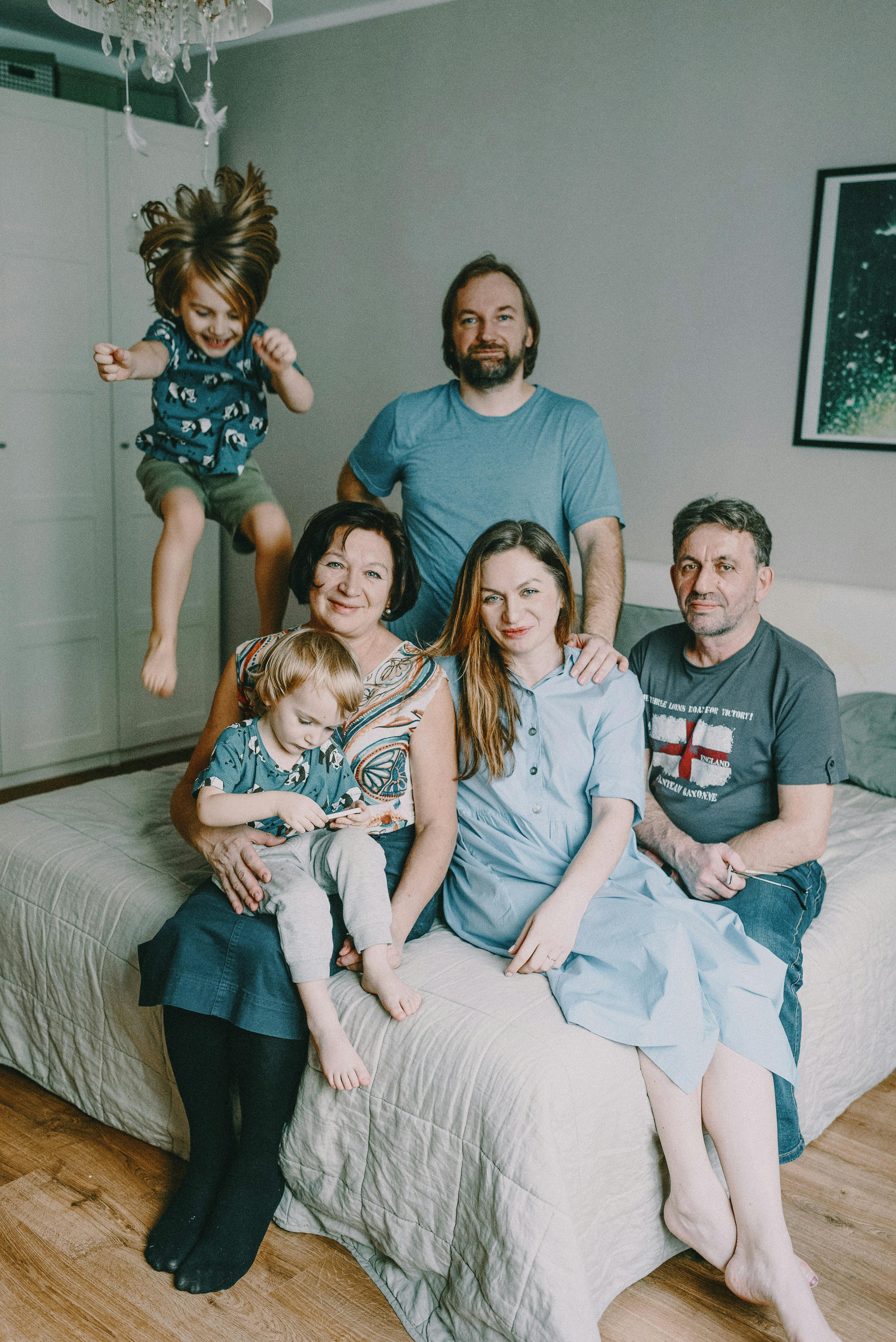 Multigenerational Florida family — grandparents, parents, and children gathered together on a bed, representing the dual caregiving pressures the sandwich generation balances