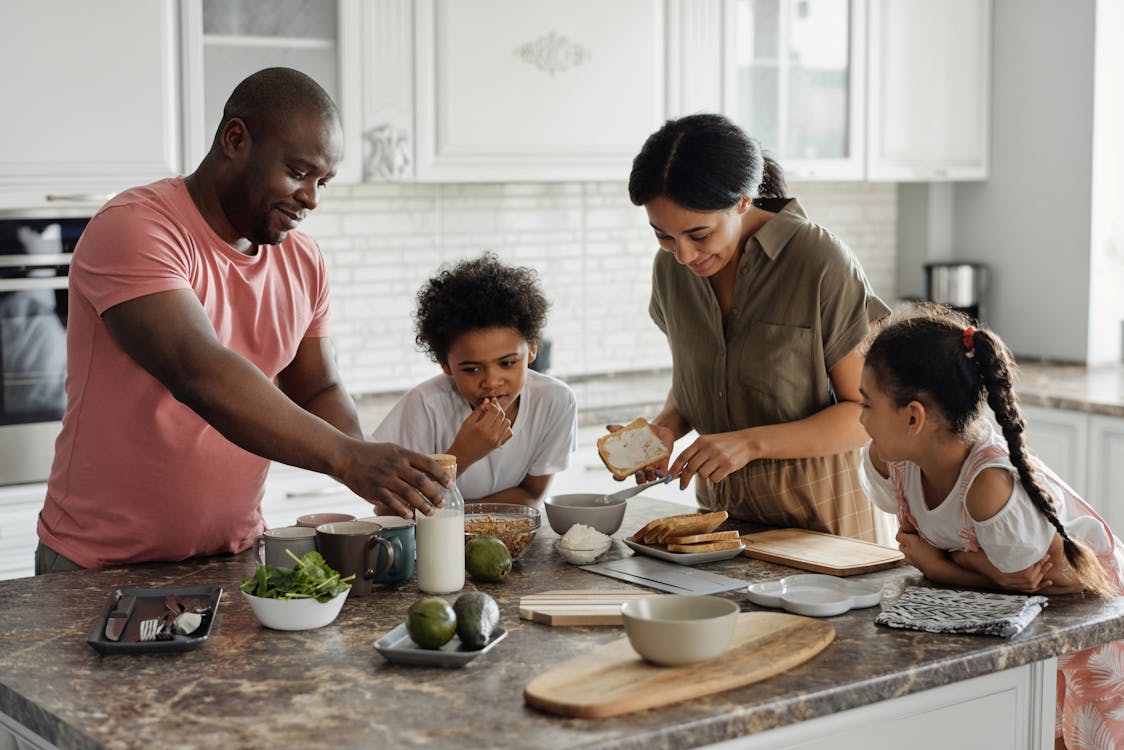 Florida multigenerational family preparing breakfast together in a bright modern kitchen, representing the everyday moments where life insurance conversations naturally come up