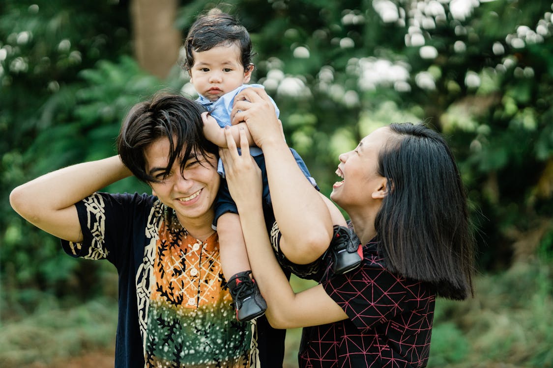 Young Florida parents smiling outdoors with their baby, representing a new family working through their first-year financial protection checklist