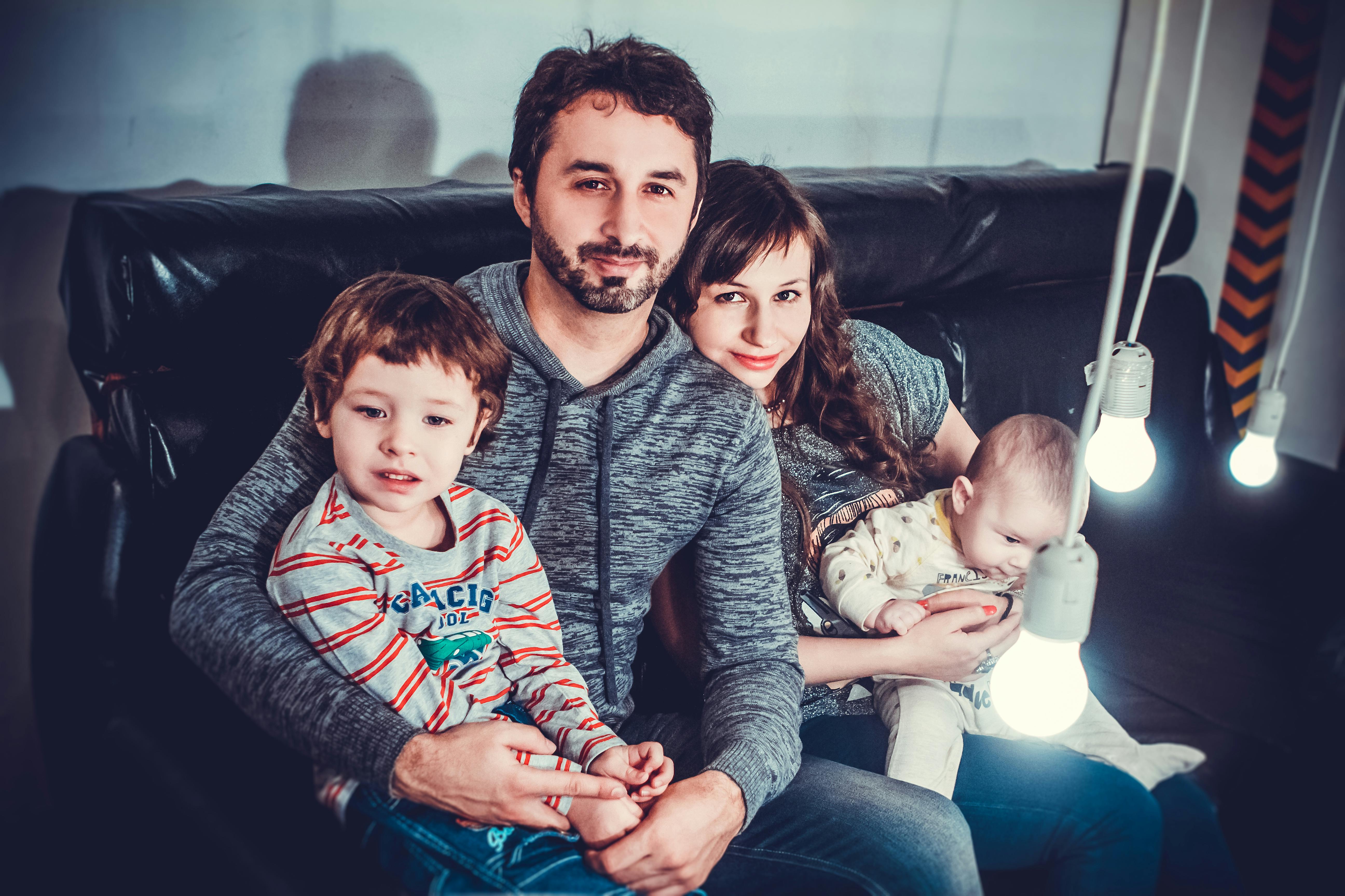 Florida family of four relaxing together on a couch at home, illustrating the household composition that benefits most from a term-plus-permanent coverage ladder