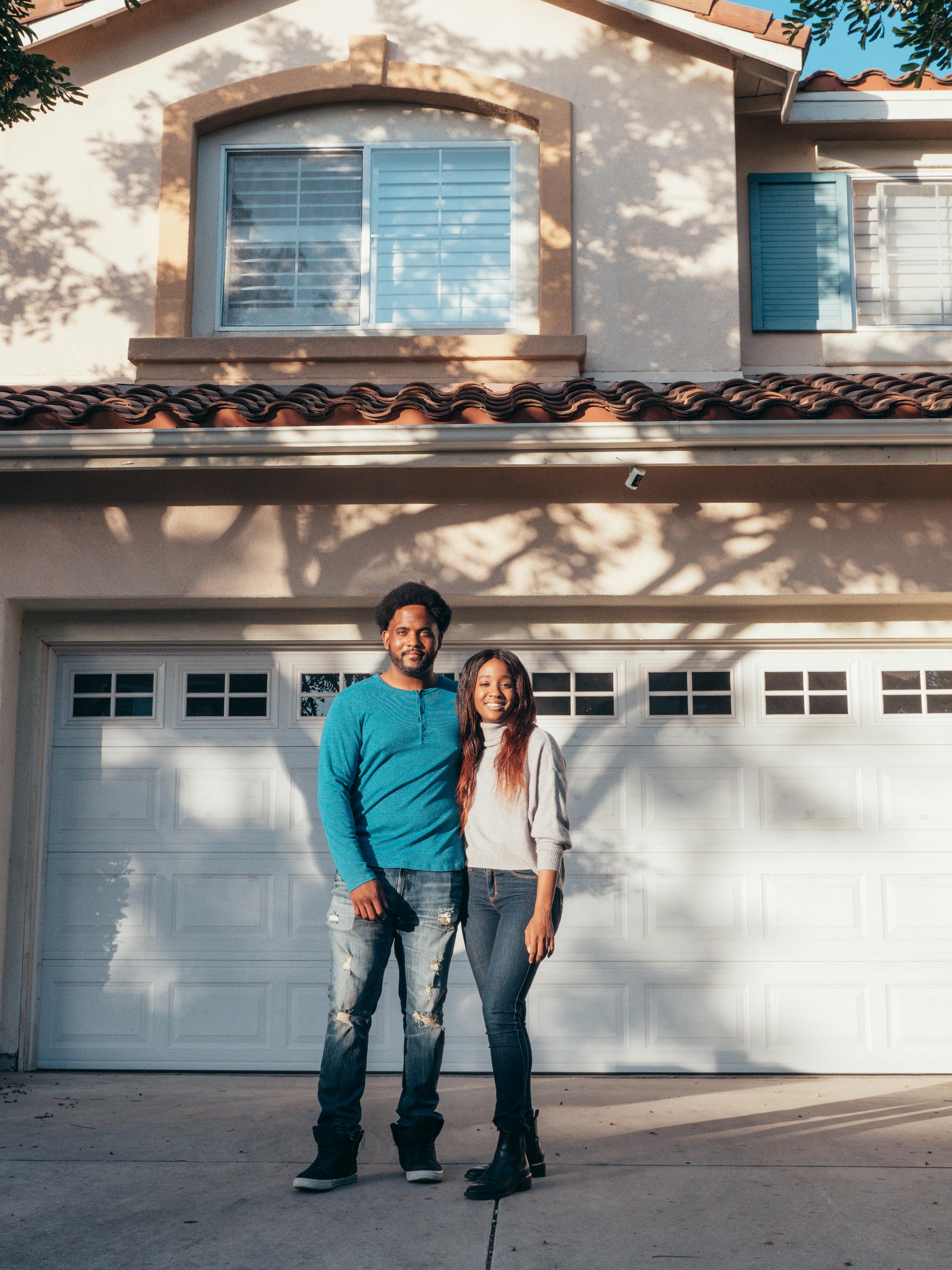 Florida homeowner couple standing in front of their newly purchased home — choosing between declining-balance and level term mortgage protection