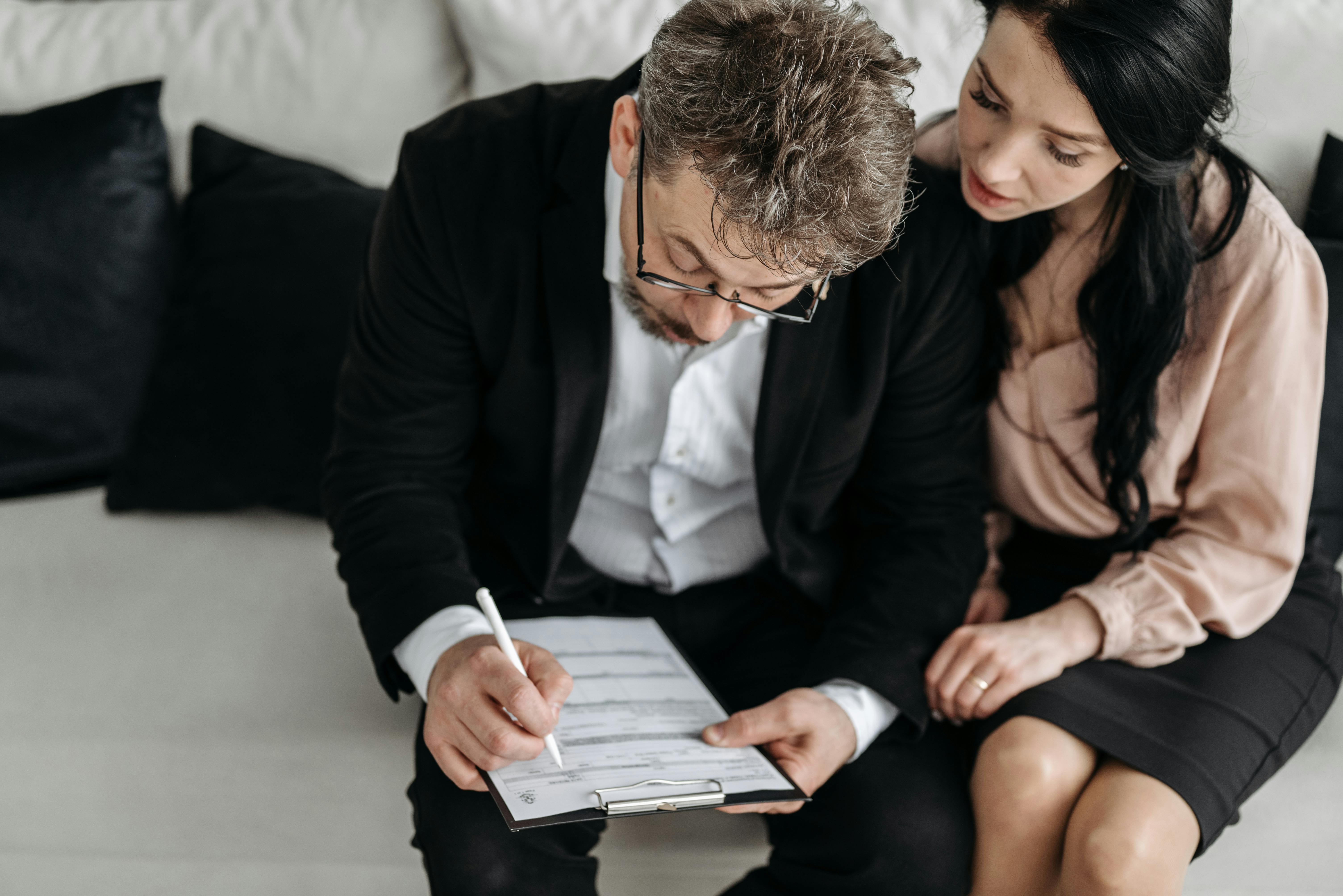 Couple sitting together reviewing whole life policy documents — examining how a paid-up additions rider shapes cash value growth